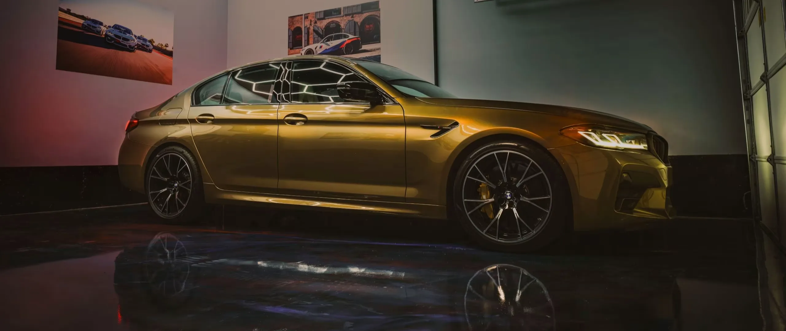 Bronze performance sedan in a dark studio garage